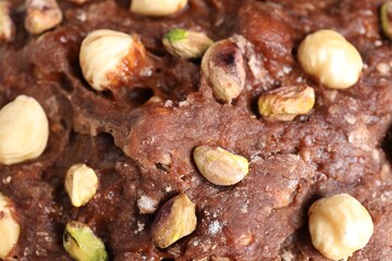 Raw chocolate dough with nuts as background, top view