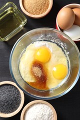 Ingredients for homemade dough on black wooden table, flat lay