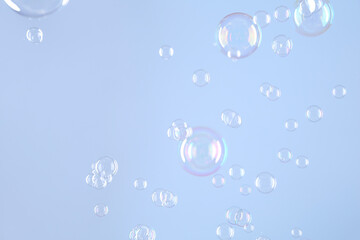 Beautiful transparent soap bubbles on light grey background