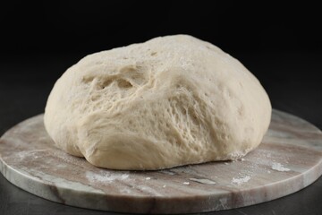 Raw homemade dough on black table, closeup