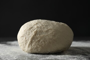 Raw homemade dough and flour on black table