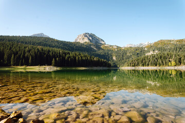 Incredible view in mountains of the lake. Rocky shore of mountain lake in the morning. Famous place for traveling