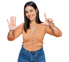Young hispanic woman wearing casual clothes showing and pointing up with fingers number seven while smiling confident and happy.