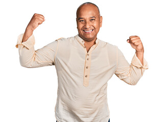 Fototapeta premium Hispanic middle age man wearing boho shirt showing arms muscles smiling proud. fitness concept.