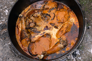 Afrikanisches Hähnchen mit Gewürzsalz eingerieben in Sauce im Dutch Oven.