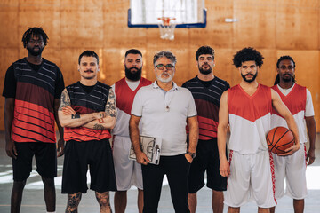 Portrait of a diverse basketball team posing while standing on a court