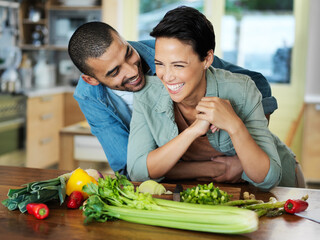 Cooking, smile and couple embrace at kitchen counter for preparation, healthy food and bonding together on date. Vegetables, happy man and vegan woman for dinner, nutrition meal or love in home