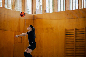 Woman volleyball athlete training or playing a match on an indoor court