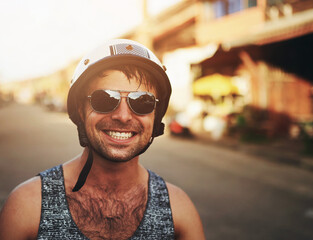 Man, closeup and smile in city with helmet for commute, sunglasses on street for holiday. Male...