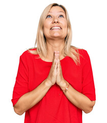 Middle age caucasian woman wearing casual clothes begging and praying with hands together with hope...