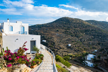View of white houses in Kastro village with mountain landscape in background, Sifnos island, Greece