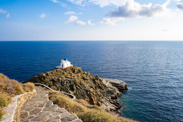 Coastal path with steps along sea leading to small church in Kastro village, Sifnos island, Greece