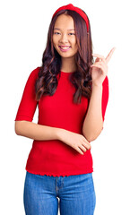 Young beautiful chinese girl wearing casual clothes and diadem smiling happy pointing with hand and finger to the side