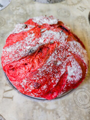 A round beet bread with cranberries on a table