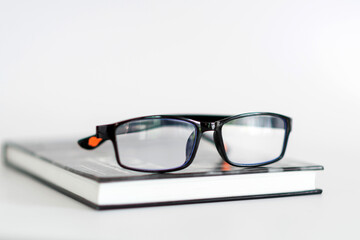 A pair of glasses sits on top of a book