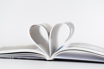 A book is open to a page with a heart shape