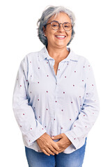Senior woman with gray hair wearing casual business clothes and glasses looking positive and happy standing and smiling with a confident smile showing teeth