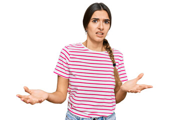 Young hispanic woman wearing casual clothes clueless and confused expression with arms and hands...