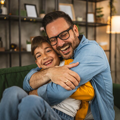 Dad hug son and share love with him spend time together at home