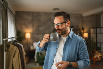 Portrait of adult caucasian man stand at home smile and hold cup