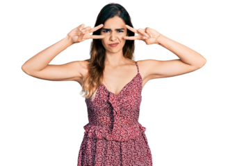 Beautiful hispanic woman wearing bohemian and hippie style doing peace symbol clueless and confused expression. doubt concept.