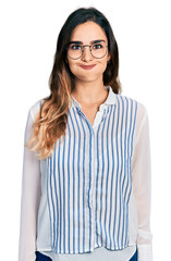 Beautiful hispanic woman wearing casual striped shirt puffing cheeks with funny face. mouth inflated with air, crazy expression.