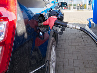 Gasoline at gas station. Refueling car fill with petrol.  Fuel nozzle in fuel tank of car.