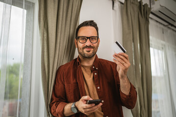 Portrait of adult man shop online with cellphone and hold credit card