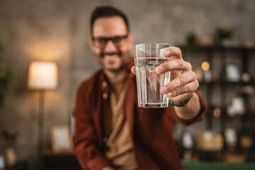 Portrait of close up adult man hand sit and toast with glass of water