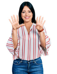 Young hispanic girl wearing casual clothes showing and pointing up with fingers number nine while smiling confident and happy.