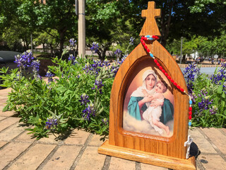 Obraz premium Small image of Our Lady of Schoenstatt resting against a background of beautiful bluebonnets