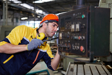 engineer or technician fixing lathe machine in the factory