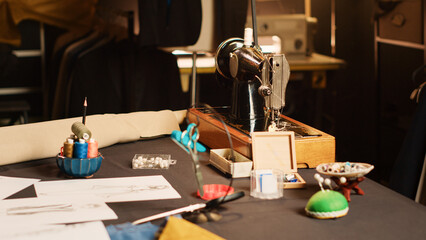 Industrial sewing machine and needles in fashion atelier, luxury craftsmanship with tailoring industry tools in workshop. Workstation with fabric and garments, manufacturing process. Close up.