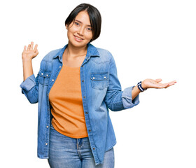 Young beautiful hispanic woman with short hair wearing casual denim jacket clueless and confused...