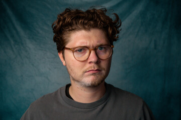 Man with Glasses Angry Portrait with Blue Background.