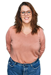 Young plus size woman wearing casual clothes and glasses with a happy and cool smile on face. lucky...