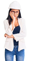 Young beautiful latin girl wearing architect hardhat and glasses thinking looking tired and bored with depression problems with crossed arms.