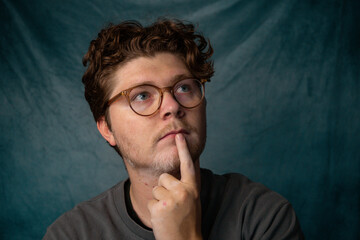 Man with Glasses Thinking Portrait with Blue Background.