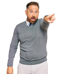 Naklejka premium Handsome middle age man wearing business clothes pointing with finger surprised ahead, open mouth amazed expression, something on the front