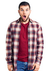 Young handsome man wearing casual shirt afraid and shocked with surprise and amazed expression, fear and excited face.