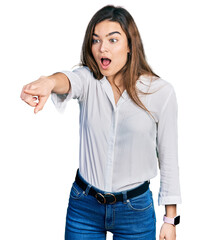 Fototapeta premium Young caucasian girl wearing casual white shirt pointing with finger surprised ahead, open mouth amazed expression, something on the front