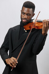Elegant African American Man in Black Suit Playing Violin on White Background Musician Performance...