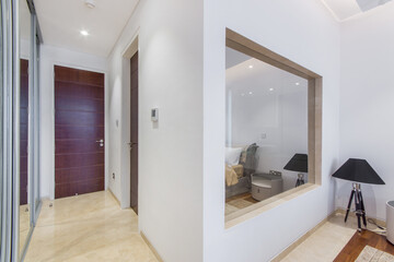 A bright corridor with a brown door and a large mirror in a sea villa..