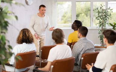 Obraz premium Confident European man, speaks to the public in the audience during a meeting of men gays