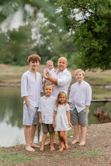 Fototapeta premium large family walks near the lake in the summer