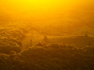 Forests of Romania. Aerial wide landscape photo of an amazing orange sunrise golden light over a...