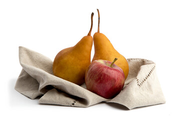two yellow Bosc pears and a red apple on a brown napkin isolated on white
