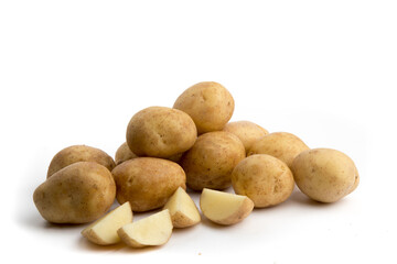 a pile of white potatoes with a cut up potatoe isolated on white
