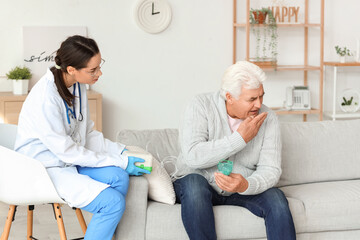 Senior man with nebulizer and nurse at home