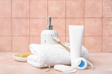 Set of bath supplies on table against color tile background